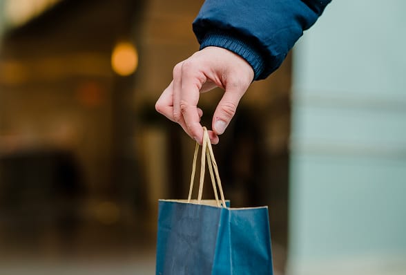 Mà que sosté una bossa de la compra que simbolitza la compra de les ulleres Spectrum Eclipse en línia